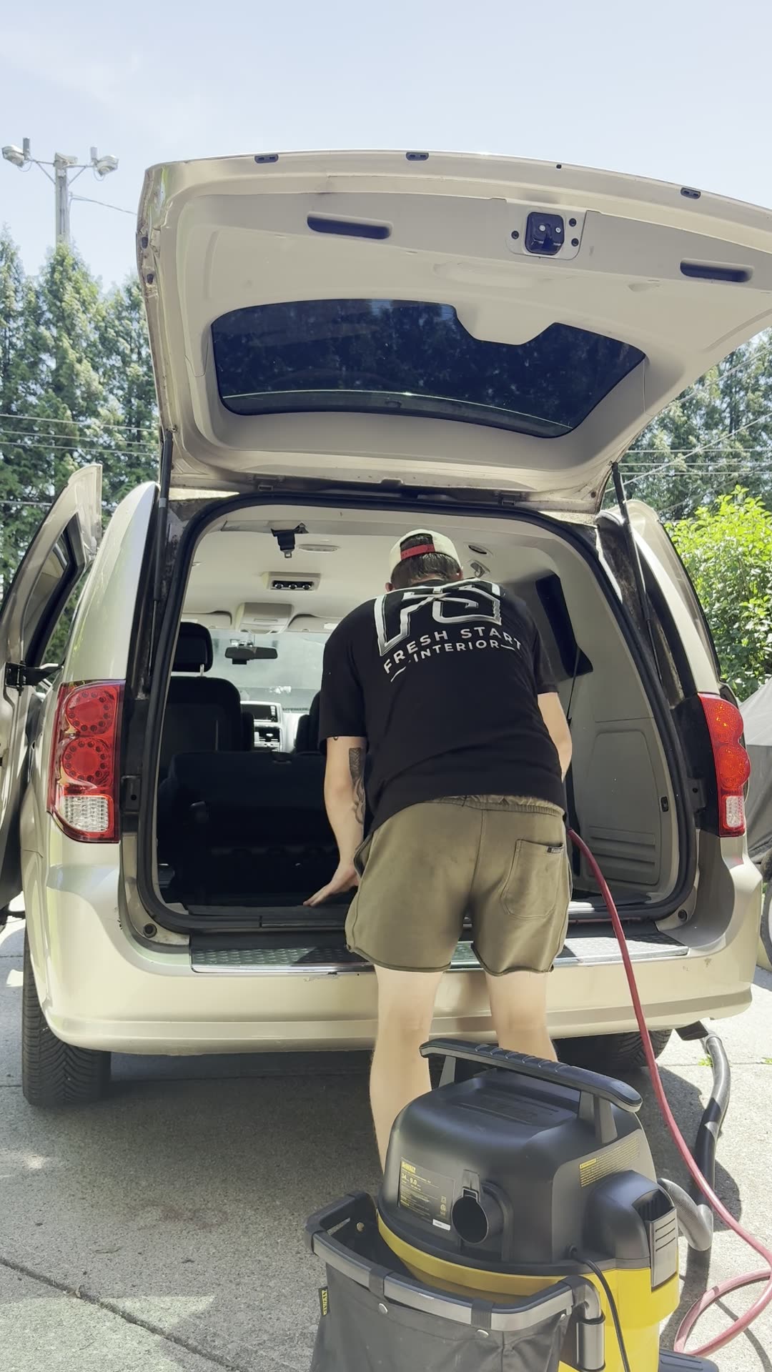 Cargo area: the cargo area of a minivan being cleaned through the open hatch